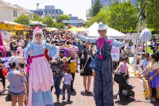 alice in wonderland themed stilt walkers welcomed everyone to the festival